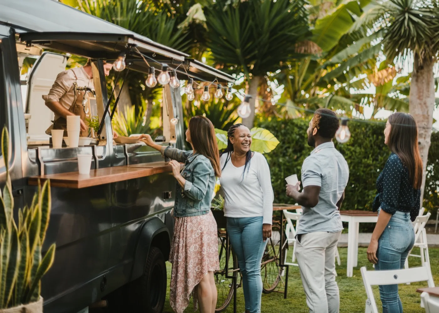 Guests ordering at a food truck under strung lights